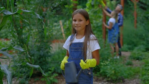 Portrait of the Little Farmer Daughter Standing in the Plantation Holding the Water Can