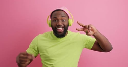 Enthusiastic man with headphones dances in studio