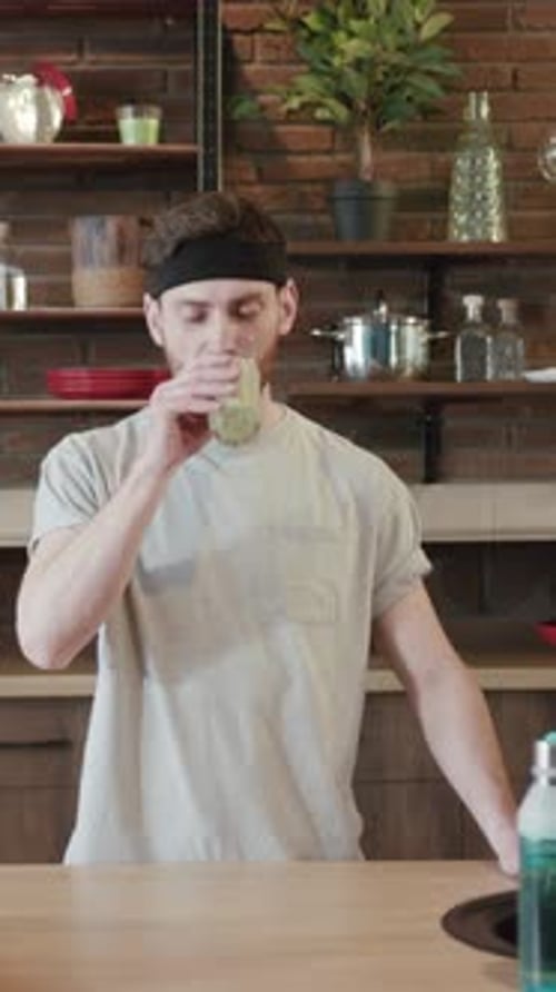 A Man Enjoying a Refreshingly Healthy Drink in a Beautifully Modern Kitchen Space