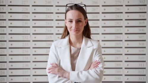Steel Mailboxes in an Apartment Building Rows of Numbered Mailboxes A Woman Stands Against the