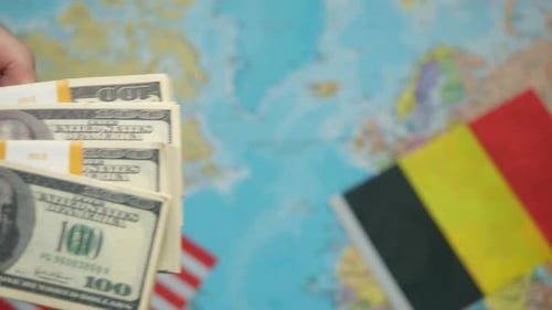 American Trade Representative Passes Stack of Dollars to Belgian Diplomat Against World Map with US