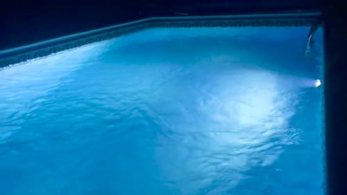 Vacant due to Covid-19 relaxing night swimming pool with led lights in slow motion