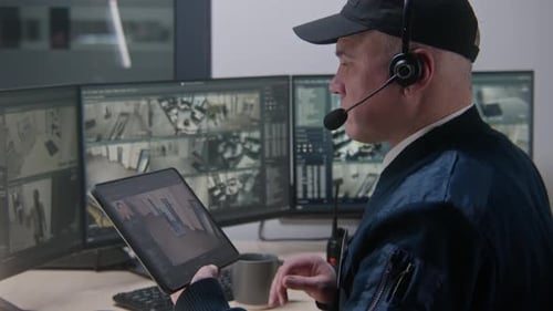 Security Guard Monitoring Surveillance Footage in Control Room