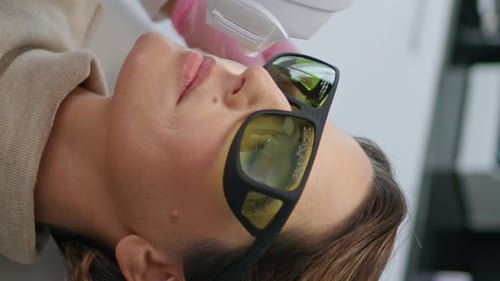 Beautician Making Facial Treatment with Laser Device in Clinic Vertical Closeup