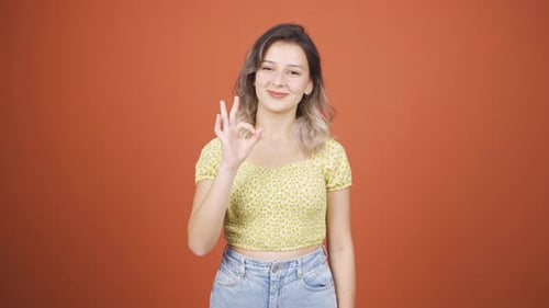 Young Woman Making Ok Sign in Studio