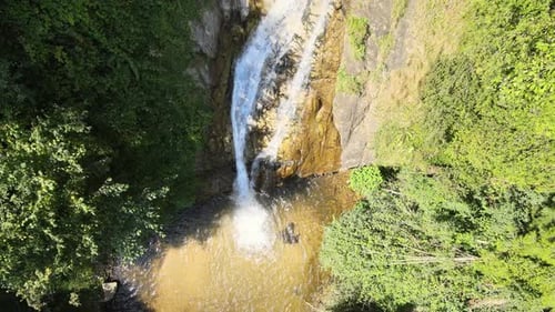 Tropical Waterfall Cascading Down Rocky Hillside
