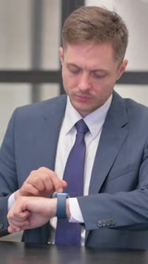 Vertical video, Young Businessman Using Smartwatch in Office