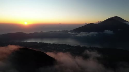 Aerial view of Batur volcano summit in clouds at sunrise, Bali, Indonesia