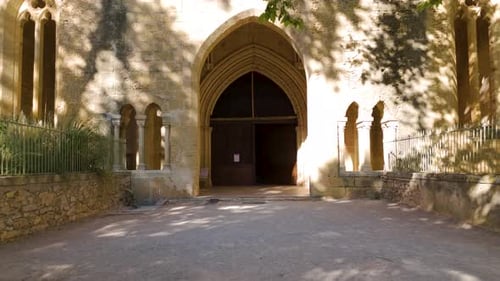 Slow dolly shot towards a wooden doorway within a french abbey