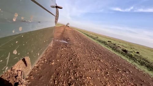4wd-Safarifahrzeug fährt auf unbefestigter Straße in Afrika — Rückblick aus flachem Winkel