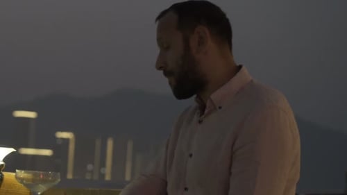 Impatient Man Waiting for Someone in Bar at Night, Checking Phone And