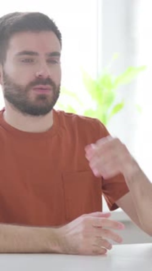Young Man Sitting in Office and Thinking, Vertical Video