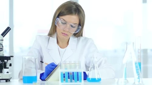 Female Scientist Writing Details Result of Research in Laboratory