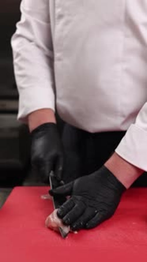 The chef prepares a dish of meat in the kitchen. Close-up