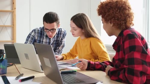 Young Adults Collaborating on Laptops in Office