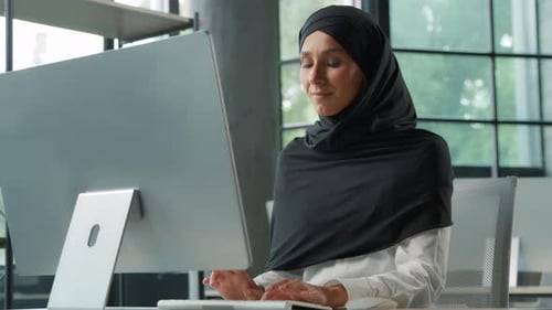 Arabian Muslim Concentrated Business Woman in Hijab Working on Computer in Office Islamic