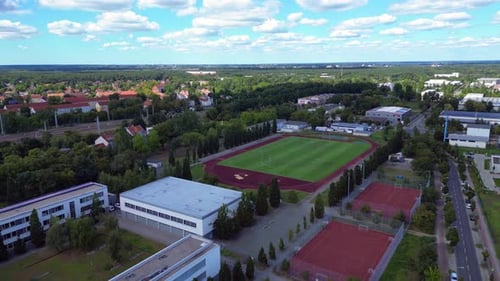 high school with big green sports Court and Soccer field. Great aerial view flight drone