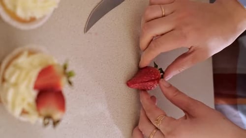 Decorating Cupcakes with Fresh Strawberries in Home Kitchen