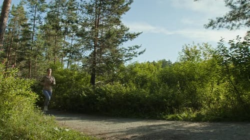 Young Man Jogging Together with his Girlfriend in Forest