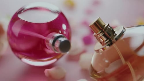 Flacons de parfum élégants sur une surface rose avec des pétales créant un effet luxueux