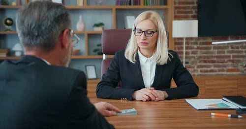 Businessman Giving Bribe to Confident Blonde Law Abiding Businesswoman,She,in Turn,Refuses the Money