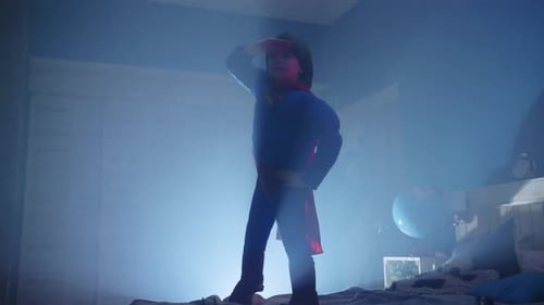 Young Child Posing as a Superhero in Bedroom