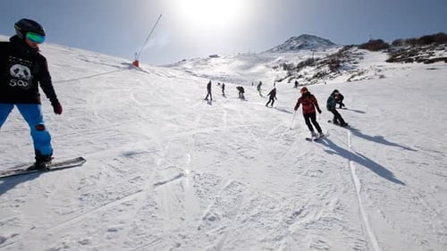 Young People Skiing On The Mountain