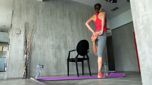 Woman Stretching on Yoga Mat at Home