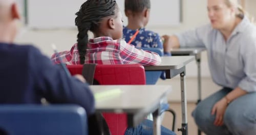 Smiling girl sitting at desk in school classroom, enjoying learning environment