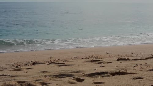 Slow Motion Sea Waves with White Foam Washing Clean Sandy Beach