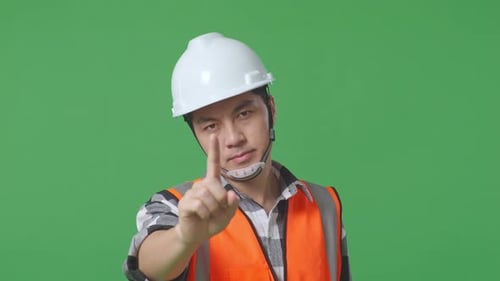 Close Up Of Male Engineer With Safety Helmet Disapproving With No Index Finger Sign On Green Screen