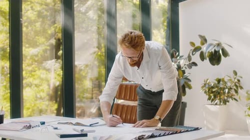 Designer Making Adjustments in Layouts in Fashionable Studio