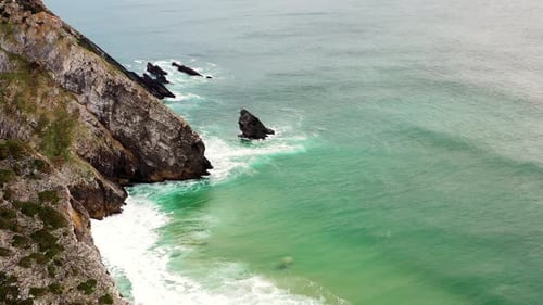 Aerial View of Rocky Cliff Coastline with Ocean Waves