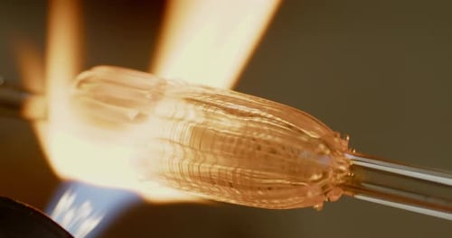 close up of glass art being heated by glass blowing craftsman