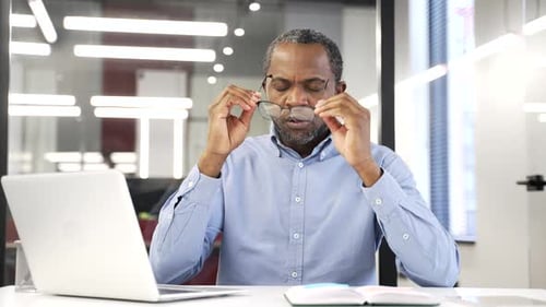 Adult Man Taking Off Glasses in Office