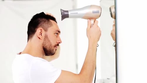 Man Drying Hair in Bathroom with Hairdryer