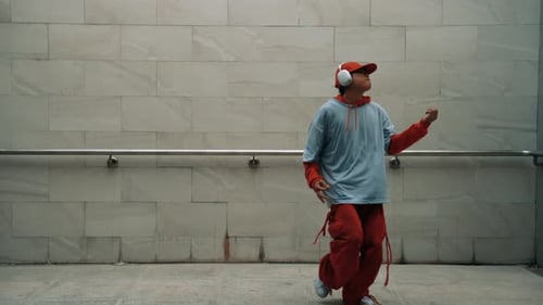 Handsome choreographer practice street dance in gray background. Sprightly.