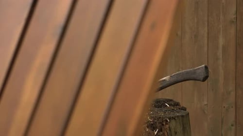 Used fire wood cutting or chopping axe sits in log stump revealed 4k slow motion shot in backyard be