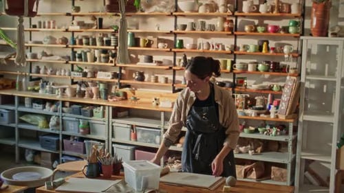 Female Ceramic Artist Working with Clay in Pottery Studio