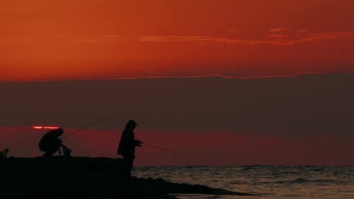 People Fishing at Sunset on the Ocean