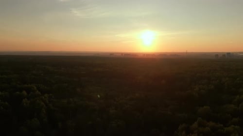 Coucher de soleil serein sur une ville lointaine Le coucher de soleil calme peint les arbres et la ligne d'horizon avec des teintes chaudes et lumineuses