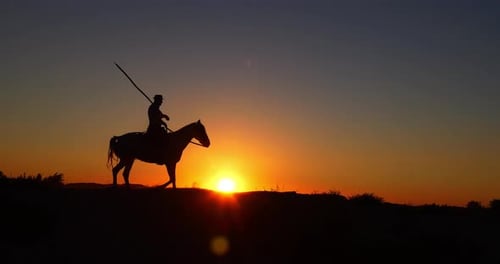 Cowboy Rides Horse Silhouette at Glorious Sunset