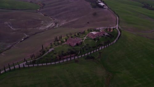 Aerial view of sunset villa with cypress trees, Tuscany, Italy.