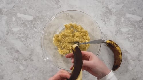 Adding Overripe Bananas to a Bowl of Mash