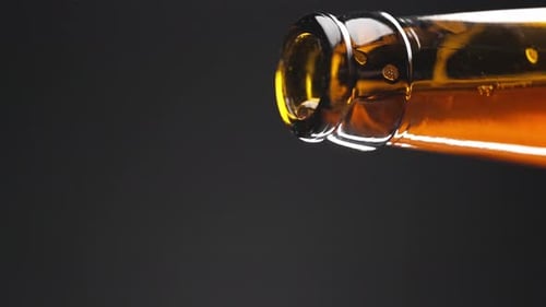 Beer being poured from a beer bottle close-up and slow motion.