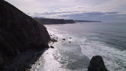 Wild pebble beach in north Spain, Asturias. Aerial backward shot over the Cantabrian Sea in