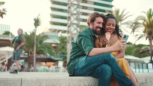 Close up of happy man and smiling woman watching video on smartphone