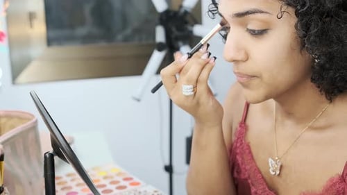Woman Applying Eyeshadow with Brush in Home