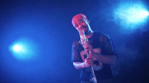 Rapper Singing and Performing on a Stage with Blue Lights