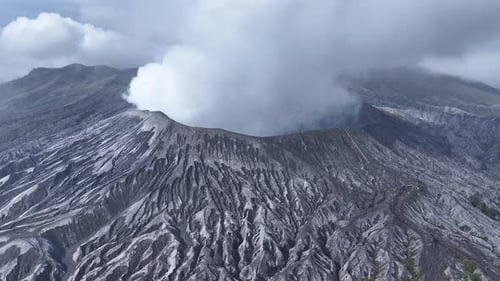 aerial view flying to mount Bromo active volcano above sea of clouds, Java, Indonesia